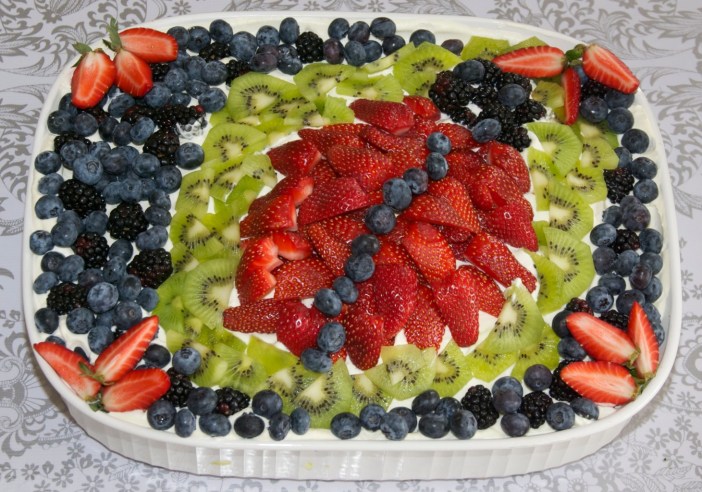 Whipped cream and fresh fruit for a bug-themed birthday cake by Jewels at Home.