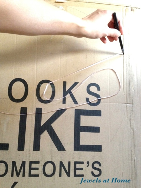 Draw a large circle on cardboard by taping a string to the center and a pen to the perimeter.